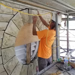 Mason repairing the stonework on a building