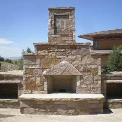 Stone masonry fireplace on the back patio